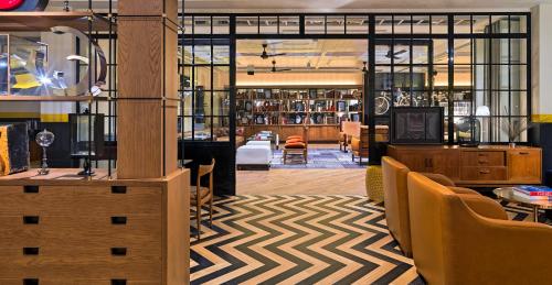 a lobby with a library with tables and chairs at H10 Metropolitan 4* Sup in Barcelona