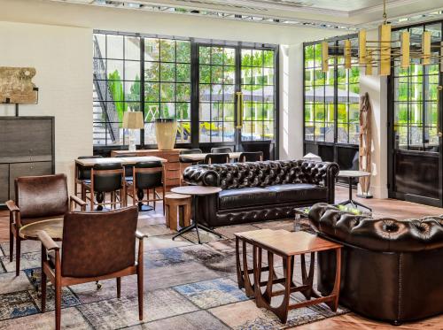 a living room with couches and tables and windows at H10 Metropolitan 4* Sup in Barcelona