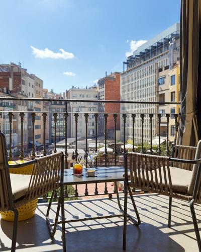 a balcony with two chairs and a table on a balcony at H10 Metropolitan 4* Sup in Barcelona