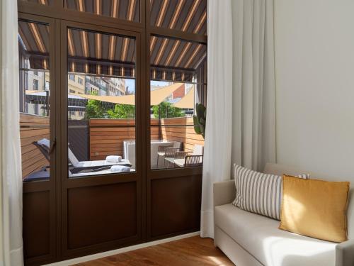 a living room with a sliding glass door with a balcony at H10 Metropolitan 4* Sup in Barcelona