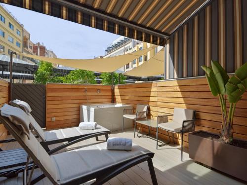 a balcony with chairs and a table and a grill at H10 Metropolitan 4* Sup in Barcelona