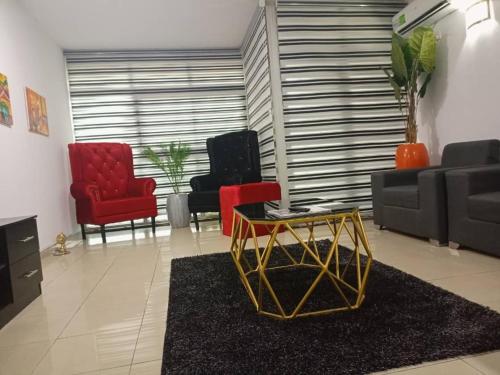 a living room with two red chairs and a couch at 2 bedroom apartment at 1004 Estate in Lagos
