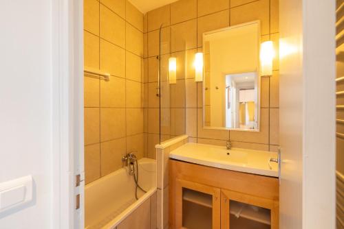 a bathroom with a sink and a tub and a mirror at Flaine- Appartement 7 personnes in Flaine
