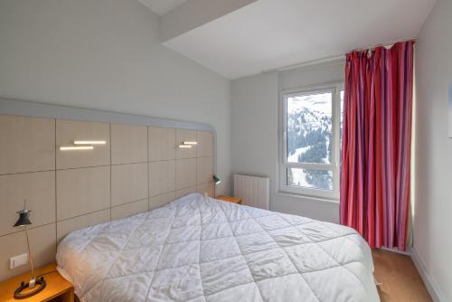 a bedroom with a large bed and a window at Flaine- Appartement 7 personnes in Flaine