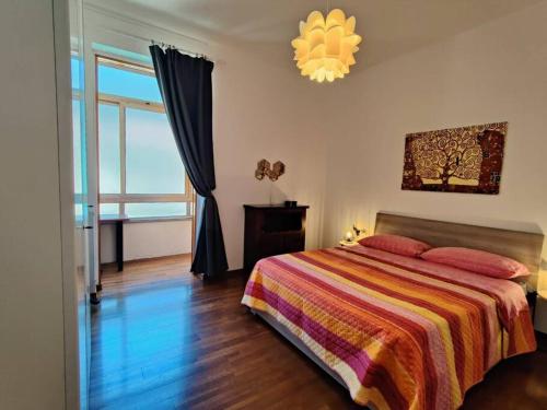 a bedroom with a bed and a large window at a mio agio apartment in Lecco