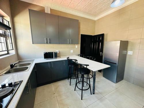 una cucina con bancone e sgabelli di The Curve Apartments Unit 16 a Johannesburg