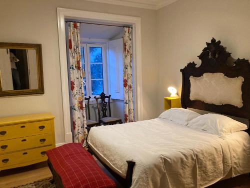 - une chambre avec un grand lit et une fenêtre dans l'établissement Junqueira Gardens - Casa Antiga Jardim e Piscina, à Lisbonne