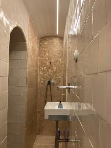 La salle de bains est pourvue d'un lavabo et d'un mur en pierre. dans l'établissement Junqueira Gardens - Casa Antiga Jardim e Piscina, à Lisbonne