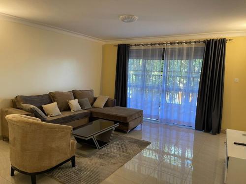 ein Wohnzimmer mit einem Sofa und einem Tisch in der Unterkunft Munyonyo Apartment in Kampala