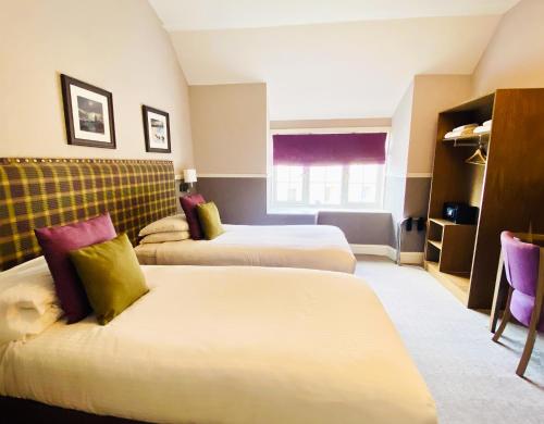 a hotel room with two beds and a window at Balmacara Hotel in Kyle of Lochalsh