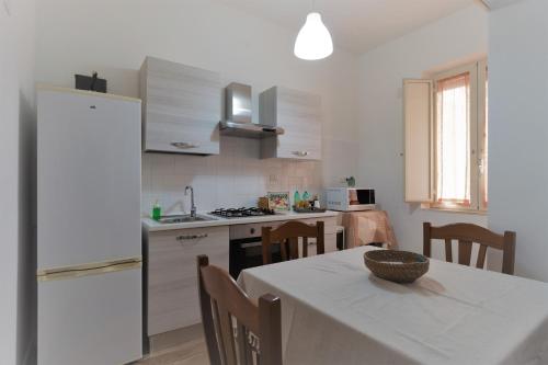 een keuken met een tafel en een witte koelkast bij Merylì House in Napels