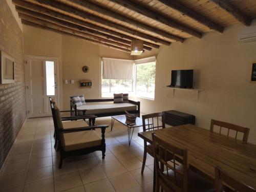 un soggiorno con tavolo e sedie e una sala da pranzo di Cabañas EL AGUARIBAY a Barreal