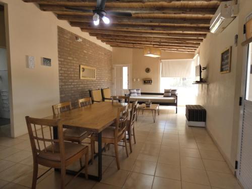 comedor con mesa de madera y sillas en Cabañas EL AGUARIBAY en Barreal