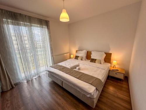a bedroom with a bed and a large window at Holiday Apartment in Ghimbav