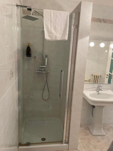 een douche met een glazen deur naast een wastafel bij Adua Exclusive Suite in Bari