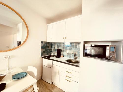 eine Küche mit einem weißen Kühlschrank und einer Spüle in der Unterkunft MER-Veilleux Repos **** in Palavas-les-Flots