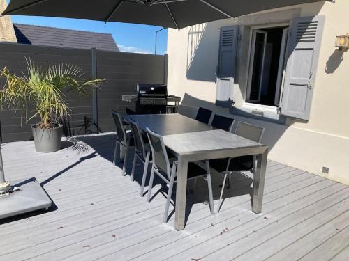 einen Tisch und Stühle auf einer Terrasse mit Sonnenschirm in der Unterkunft Villa Evalou de 240 m². in Trévignin