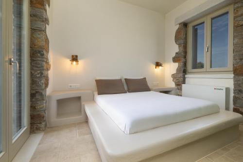 a white bed in a room with a window at Stone Haven Villas in Plaka