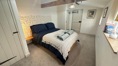 a small bedroom with a bed with blue pillows at Rural Retreat, Wood Burner, Patio, Lawn, Breakfast, new wifi in Warminster