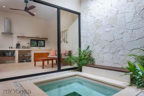 a swimming pool in a house with a living room at Casa Yaakun in Tulum