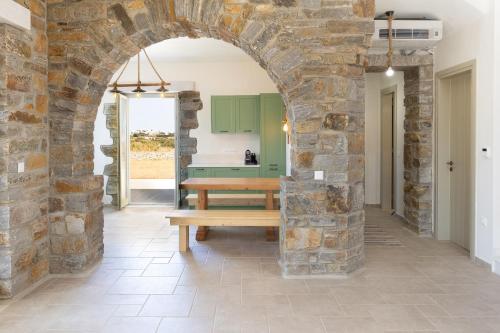 an archway in a room with a wooden bench at Stone Haven Villas in Plaka