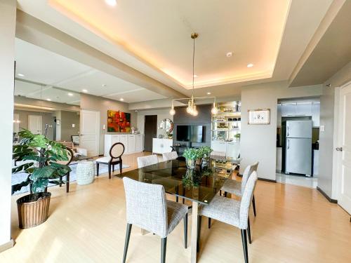 a dining room and living room with a table and chairs at Avant Spacious Sanctuary with the best view in BGC in Manila