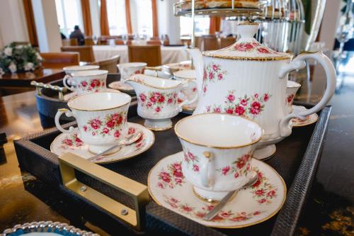 a group of tea cups and saucers on a table at HT Hotel Deluxe Resort & SPA in Santiago del Estero
