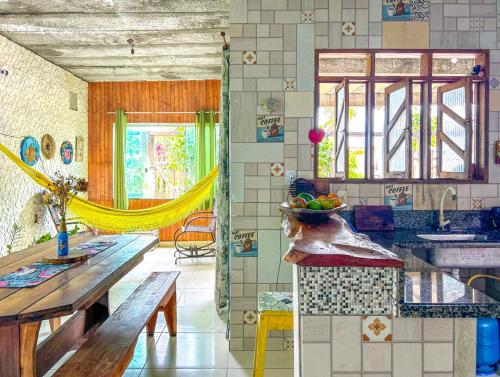 a kitchen with a sink and a table with a bowl of fruit at Otima casa proxima a praia do Acuipe em Ilheus BA in Ilhéus