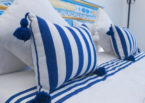 a row of blue and white pillows on a bed at CASA BLUE PEARL in Chefchaouene