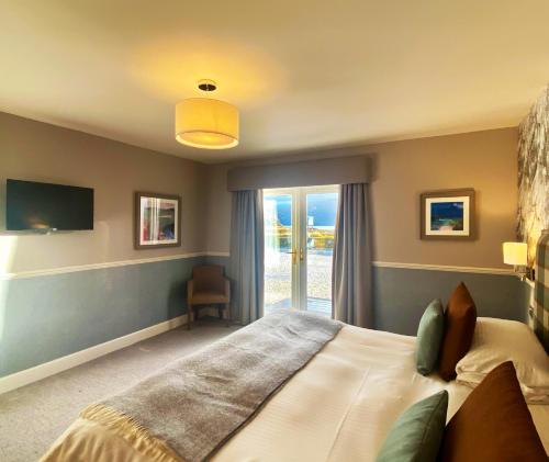 Un dormitorio con una cama grande y una ventana en Balmacara Hotel, en Kyle of Lochalsh