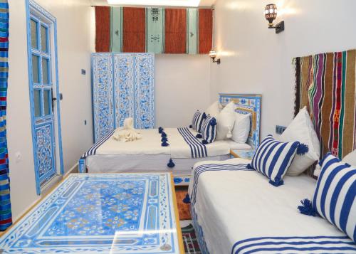 three beds in a room with blue and white at CASA BLUE PEARL in Chefchaouen