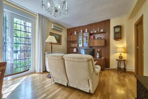 sala de estar con silla y lámpara de araña en Apartamento Carlos-1, en Madrid