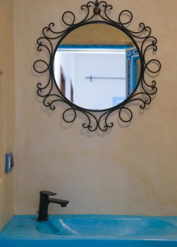 a mirror on a wall above a bathroom sink at CASA BLUE PEARL in Chefchaouene