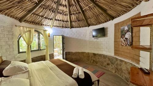 um quarto com uma cama num quarto com uma televisão em Hotel Campestre mirador CaloPala em Machetá