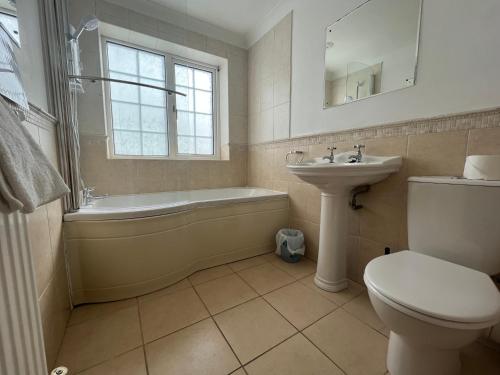 a bathroom with a tub and a toilet and a sink at Cherry Garth in Sleights