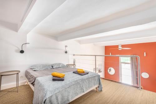 - une chambre avec un lit et des murs orange et blancs dans l'établissement Studio Pasteur centre historique, à Aix-en-Provence