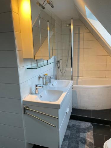een badkamer met een wastafel en een ligbad bij Sky in Winterberg