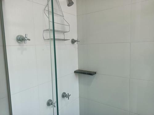 a shower with a glass door with a towel rack at Apartamento vista praça estação Centro BH in Belo Horizonte
