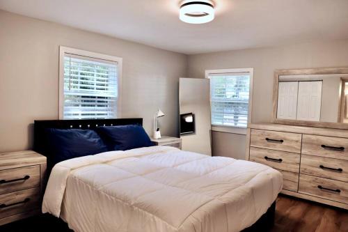 1 dormitorio con 1 cama grande y 2 ventanas en Coastal Golf Hideaway, en Wilmington