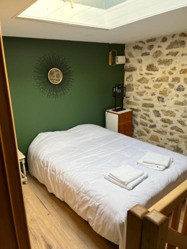 une chambre avec un lit blanc avec un mur vert dans l'établissement Villa Paul, à Wimereux
