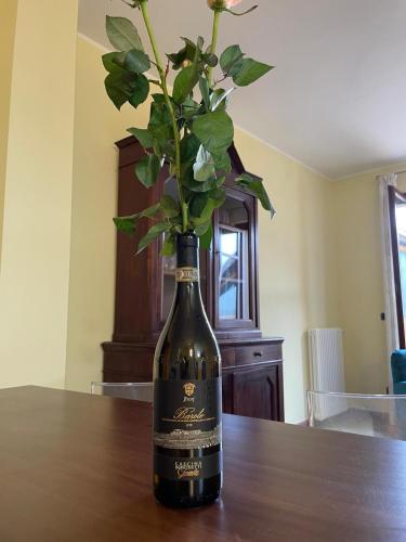 a bottle of wine with a vase with flowers in it at Cascina Boschetti in Barolo