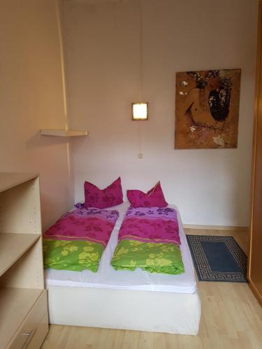 ein kleines Schlafzimmer mit 2 Betten und bunter Bettwäsche in der Unterkunft Appartement "Hope" in Greiz