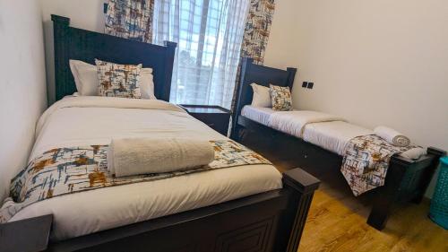 a bedroom with two beds and a window at Urban Haven 3BR Apartment in Nairobi