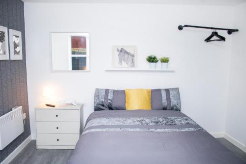 a bedroom with a bed and a white cabinet at Chill Nexus Oasis in Liverpool