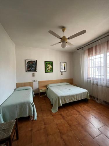 two beds in a room with a ceiling fan at orlando in Porto Garibaldi