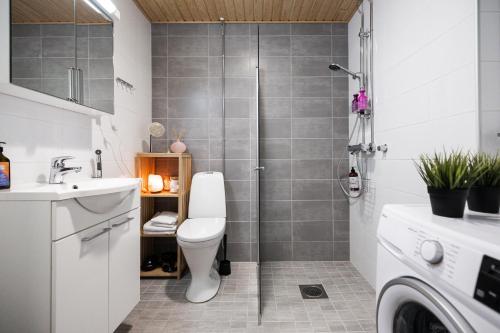 a bathroom with a shower with a toilet and a sink at Koda Apartment - Balcony - Great design and location in Rovaniemi