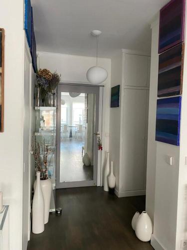 - un salon avec des vases blancs à l'étage dans l'établissement Appartement spacieux et cosy Champs Elysées Arc de triomphe, à Paris