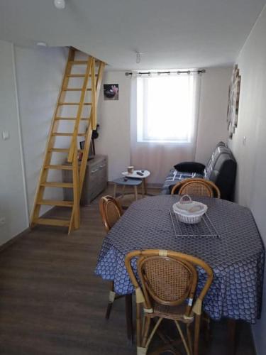 une salle à manger avec une table, des chaises et une échelle dans l'établissement Maison pour 2 à 4 personnes, à Brassac-les-Mines