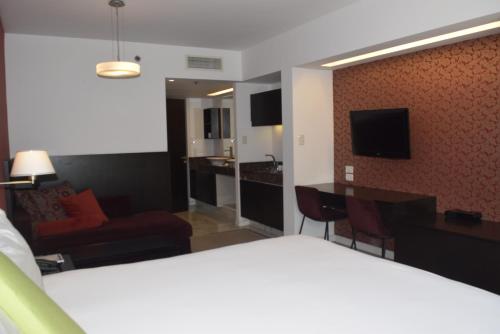um quarto de hotel com uma cama e uma sala de estar em Hotel BA Abasto em Buenos Aires