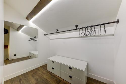 a white room with a dresser and a mirror at L'Industrie-Loft-T2-Clim-Parking à proximité in Pierre-Bénite